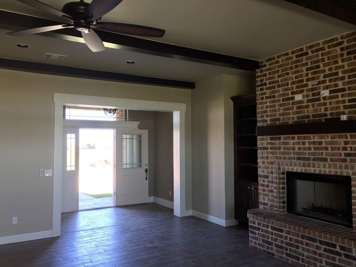 Living room with exposed beams and freshly painted walls by Baker's Painting