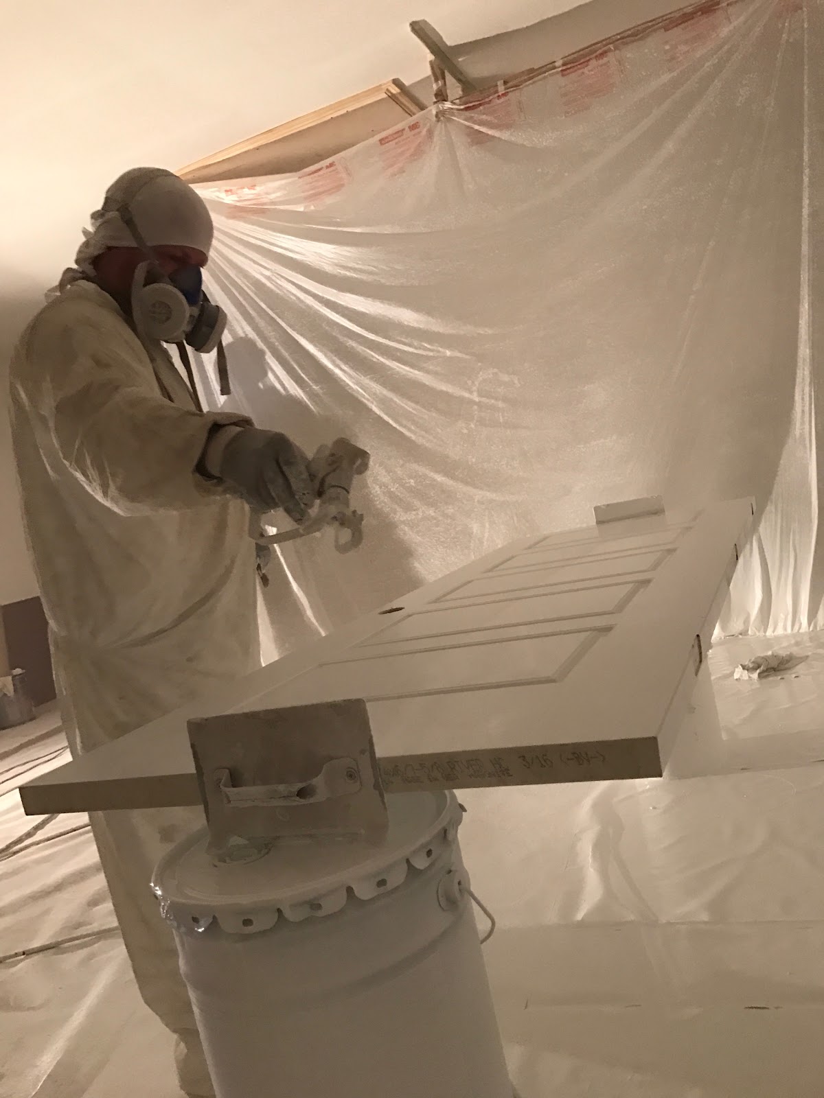 Baker's Painting crew member spray painting in full protective gear
